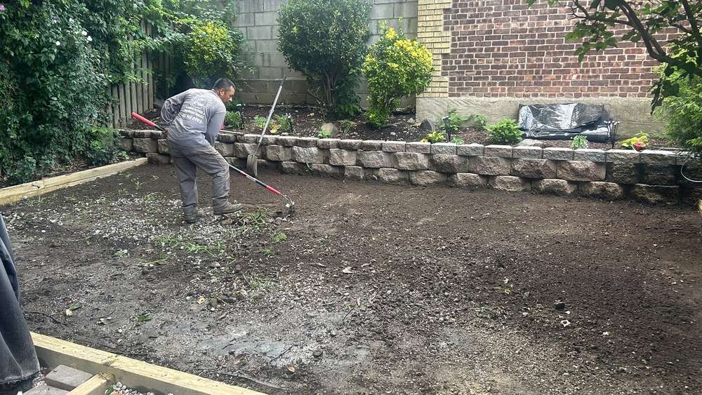 Bare soil bed prepared for artificial turf installation